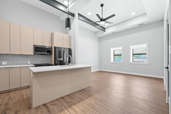 A kitchen with wooden floors and a countertop with a microwave and coffee maker.